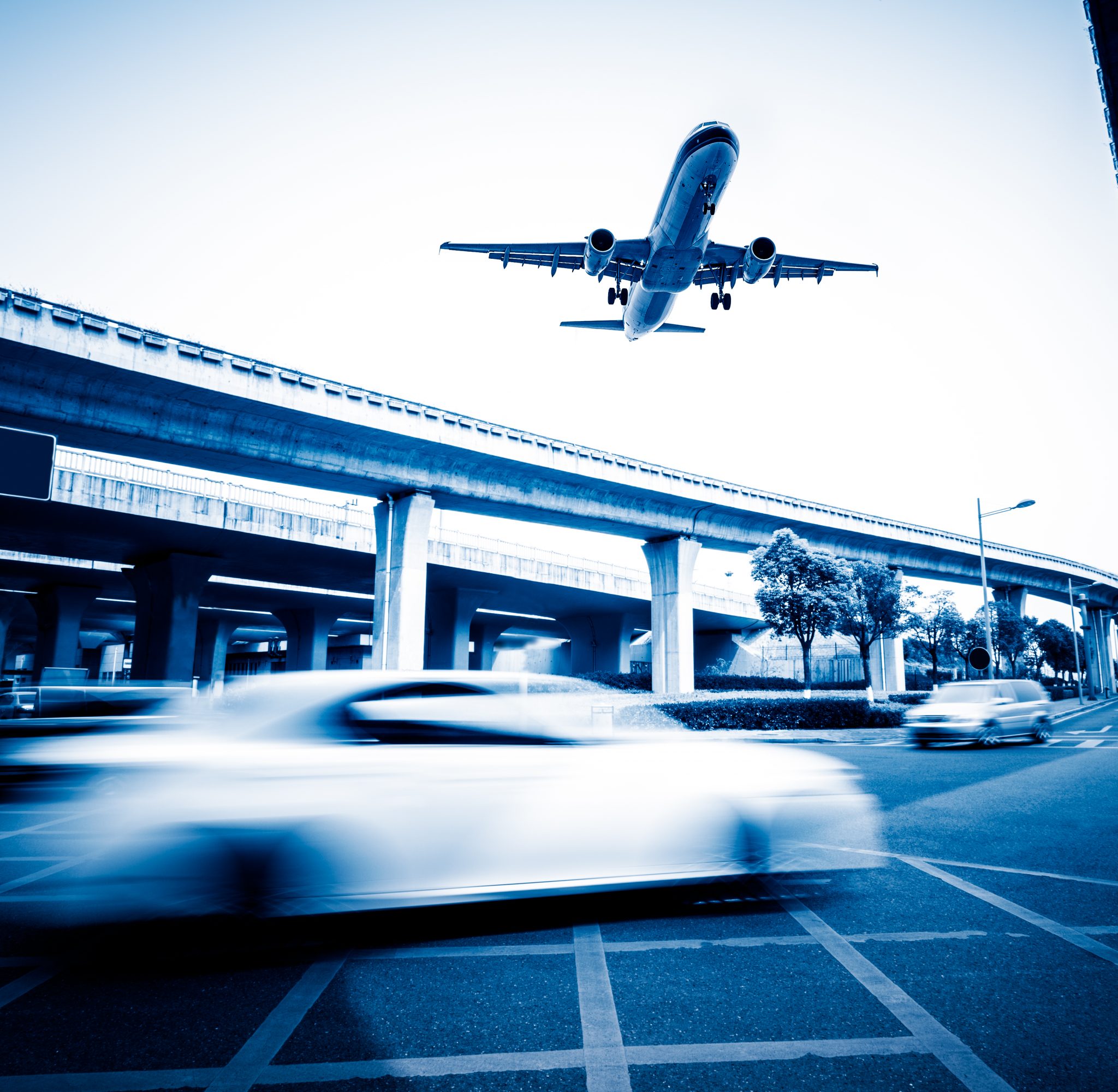 blurred-street-scene-city-with-plane-flying.jpg